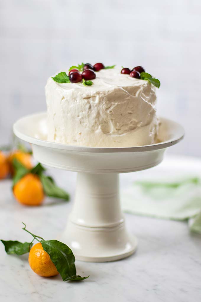 An almond flour cake shown on a white cake stand.