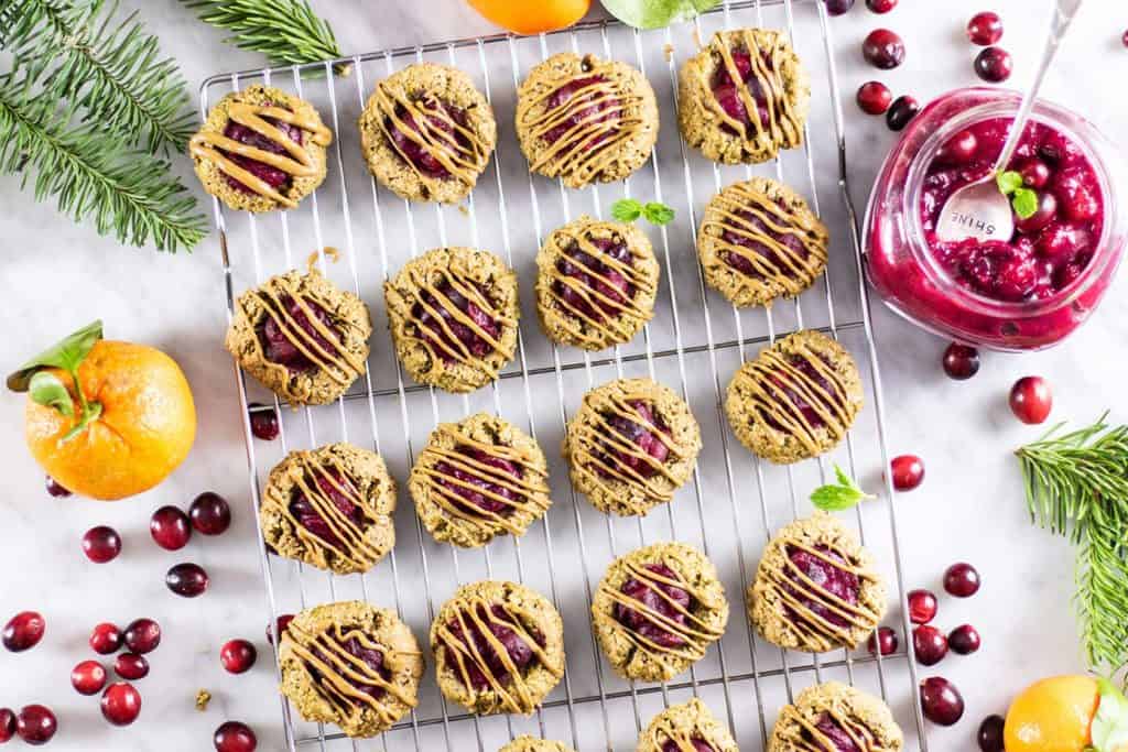 Baked cranberry breakfast cookies drizzled with sunflower seed butter cooling on a rack.