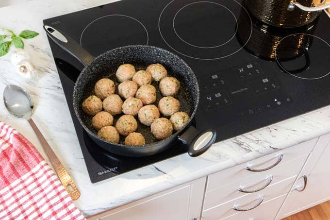 The Sharp Induction Cooktop with turkey meatballs browning in a pan.