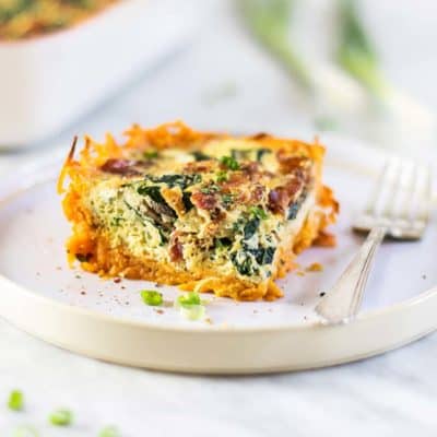 A slice of whole30 bacon quiche with a sweet potato crust on a plate.