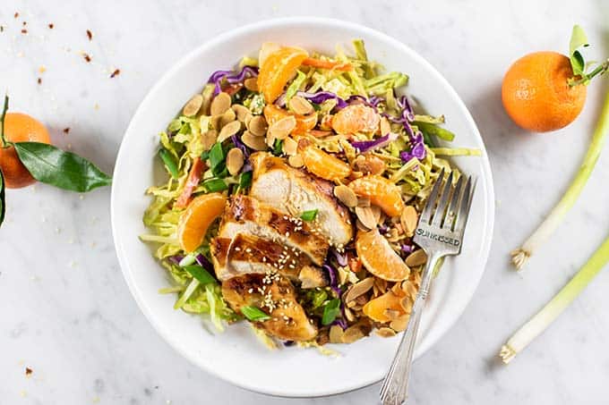 A close up of a Whole30 Chinese Chicken salad with cabbage, oranges, carrots, and almonds.
