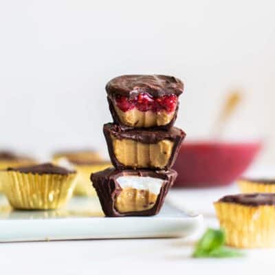 A stack of three Sunbutter cups, showing the raspberry, coconut and plain sunflower seed butter fillings.
