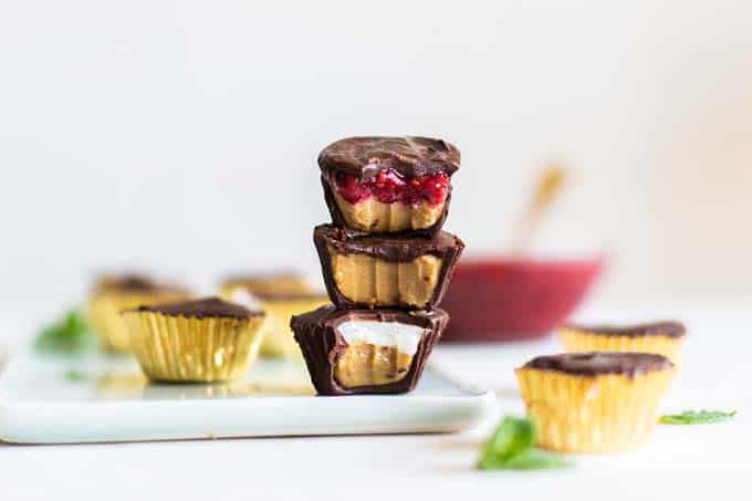 A stack of three Sunbutter cups, showing the raspberry, coconut and plain sunflower seed butter fillings.