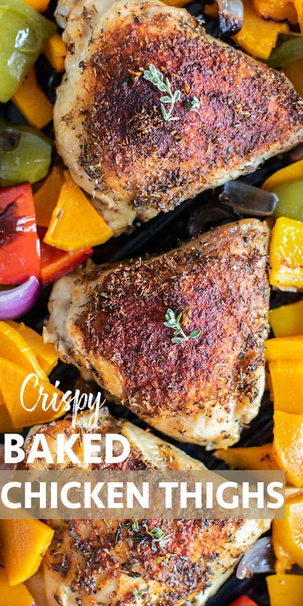 A close up of crispy baked chicken thighs surrounded by colorful vegetables.