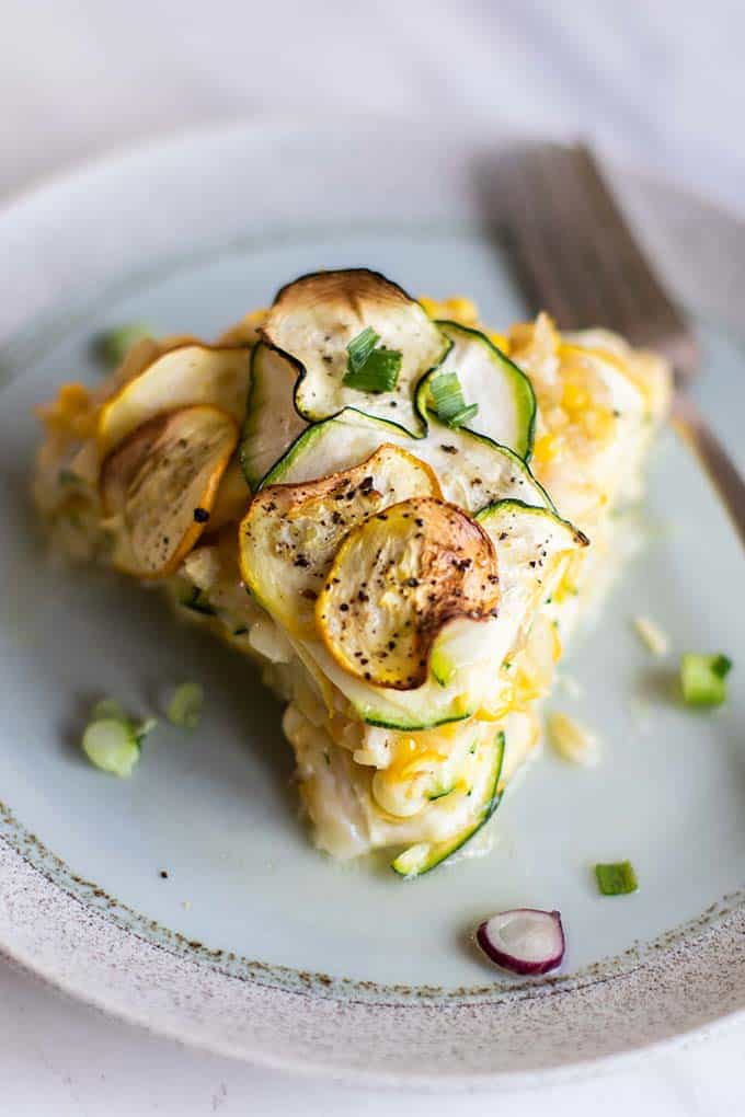 A slice of zucchini pie with crispy slices on top.