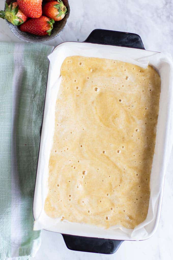 A light and airy almond flour cake batter in a cake pan.