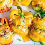 Cheesy stuffed bell peppers in a baking dish.