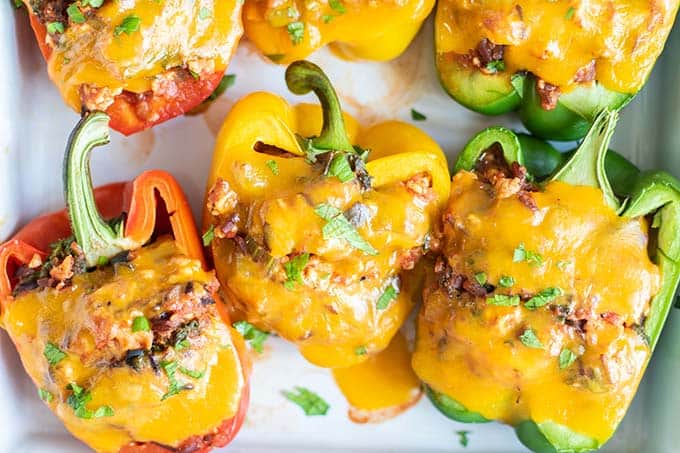 A close up shot of cheese melted over stuffed bell peppers.