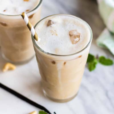 Two frosty glassed of iced vanilla coffee with a foamy top.