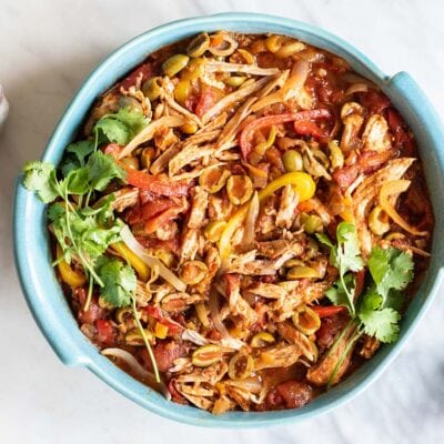 Pork ropa vieja shown in a blue casserole dish.