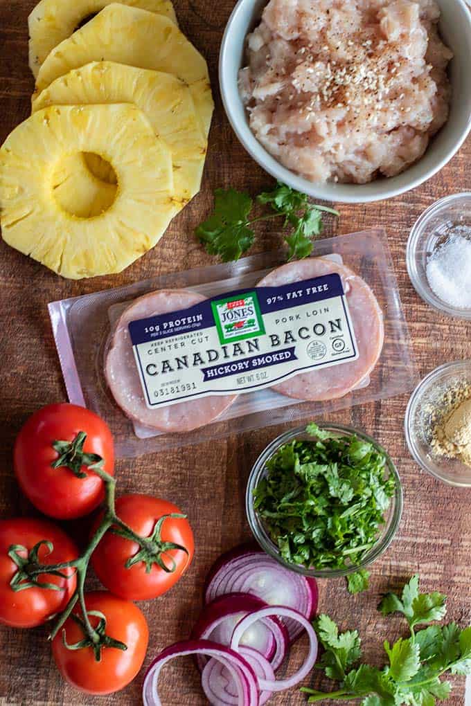 The ingredients for Hawaiian Chicken burgers laid out on a cutting board.