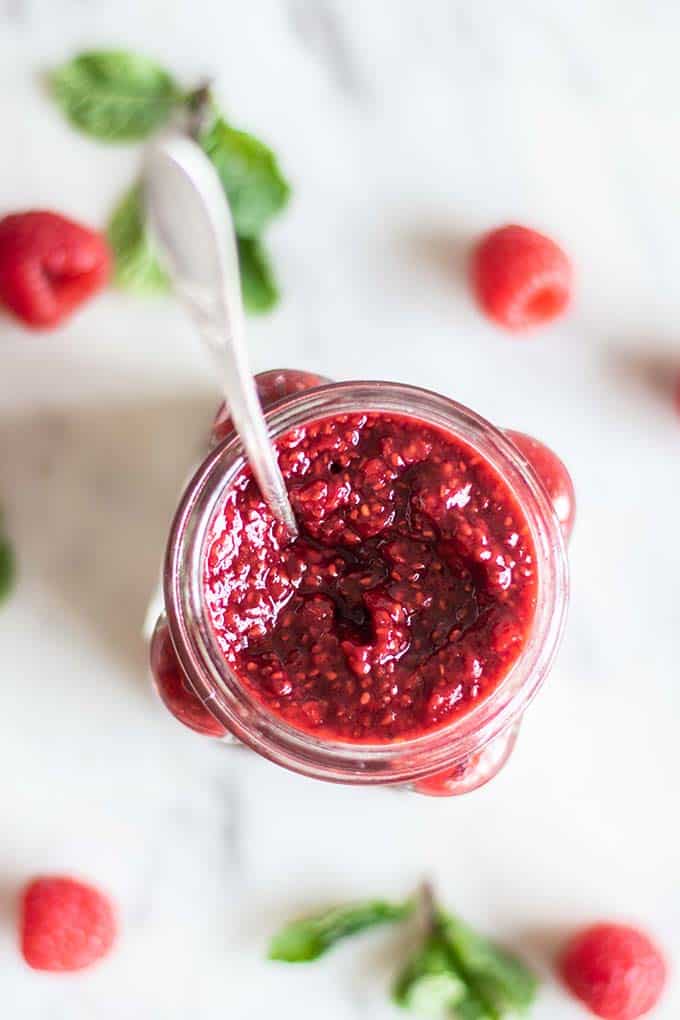 A close up shot of raspberry jam in a jar.