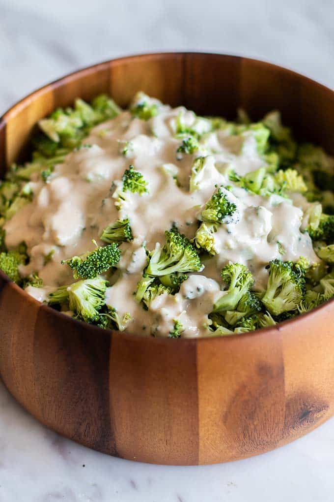 A bowl of broccoli coated in a creamy tahini dressing.