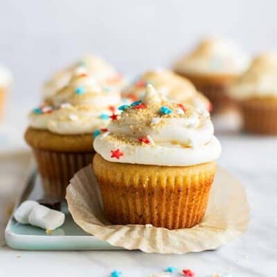 A vanilla cupcake with white icing and red, white and blue star sprinkles.