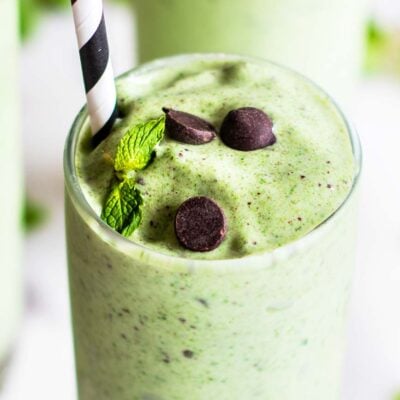 A close up look at a mint smoothie speckled with dark chocolate.