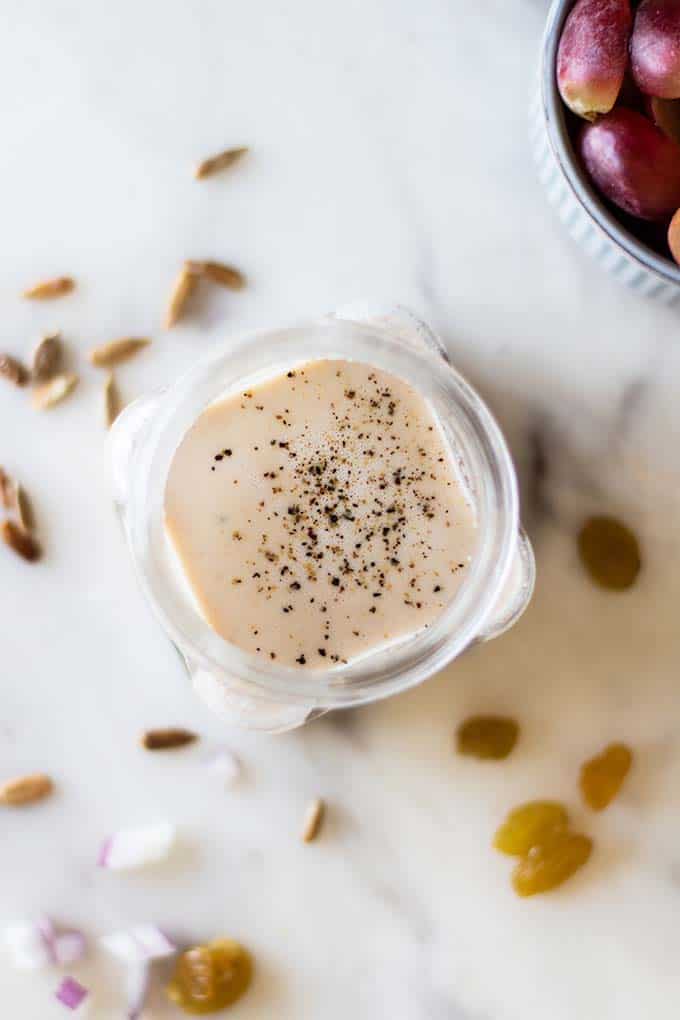 A view into a jar filled with a creamy tahini dressing.