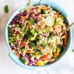 A bright and colorful Asian Cabbage Salad with Broccoli in a blue dish.
