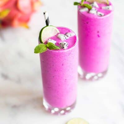 Two dragon fruit smoothies garnished with mint, lime and white dragon fruit,