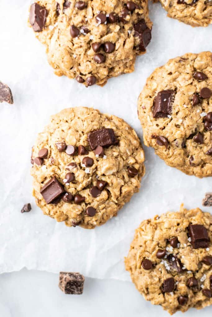 A close up of baked cookies cooling on parchment paper.