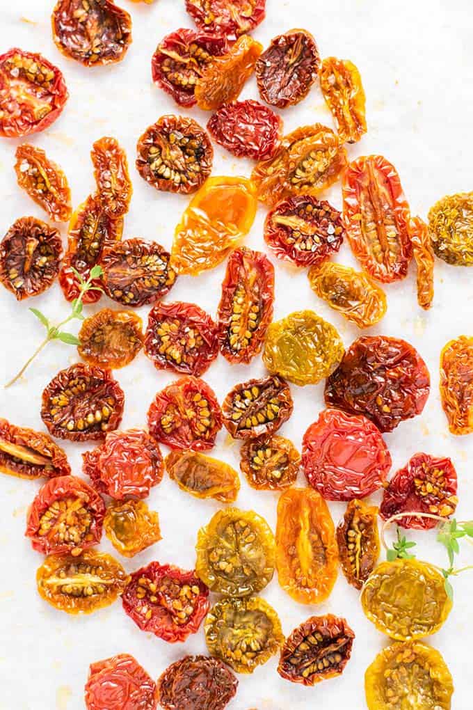 Sun dried tomatoes in a variety of colors with a few sprigs of thyme.