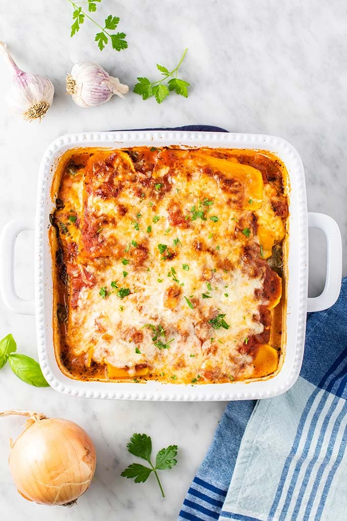 A baked butternut lasagna in a white casserole dish.