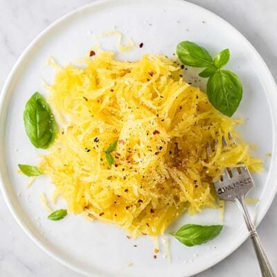 A plate with spaghetti squash and basil.