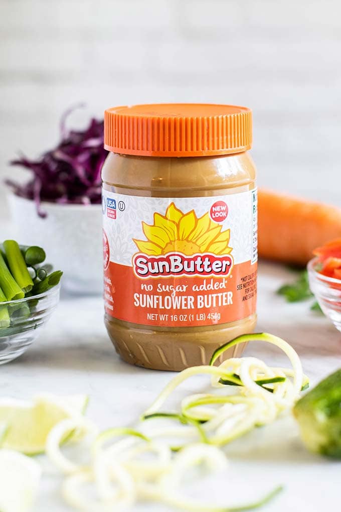 A jar of Sunbutter surrounded by the ingredients for this healthy Thai recipe.
