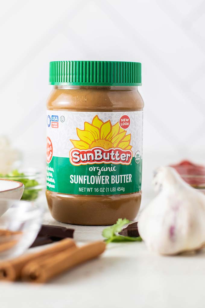 A jar of organic sunbutter surrounded by the rest of the ingredients for this dish.