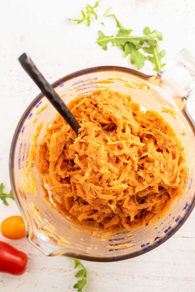 A large measuring cup with the batter for sweet potato waffles.