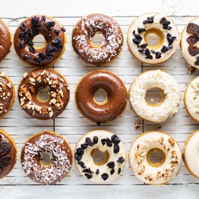 12 donuts glazed with a white chocolate and dark chocolate glaze on a cooling rack.