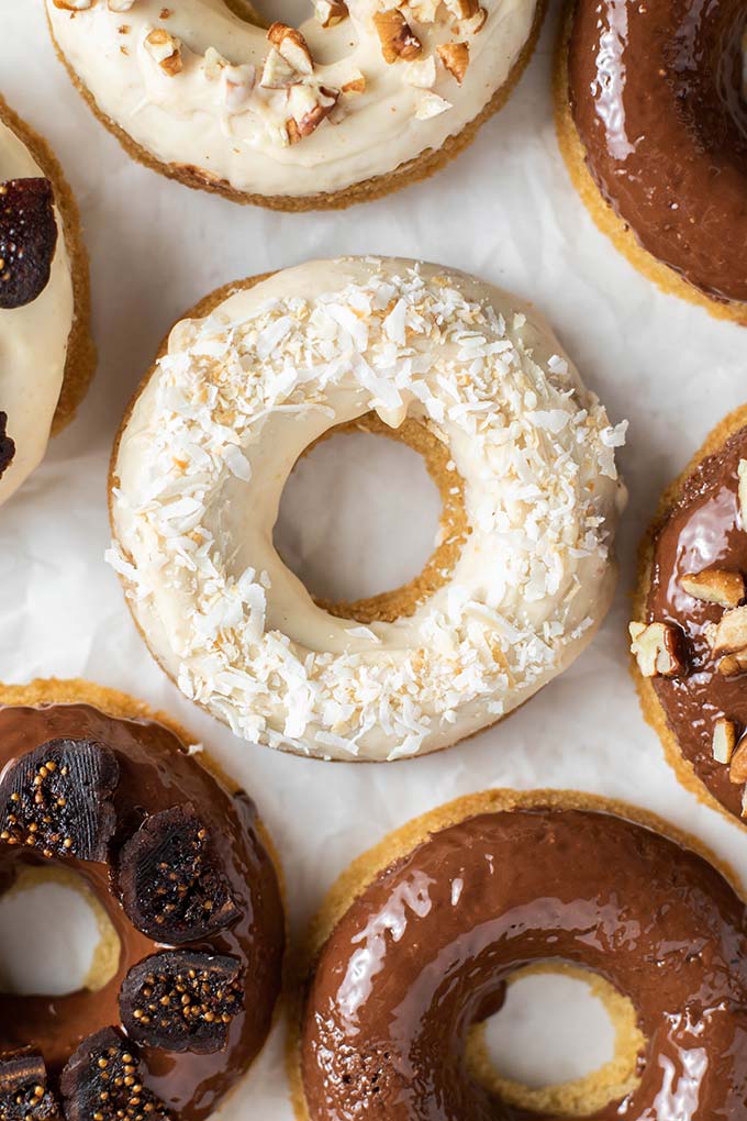 A close up look at a donut glazed with white chocolate and topped with toasted coconut.