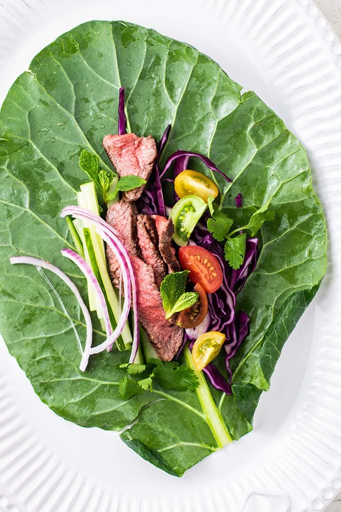 A collard green prepared and filled with steak salad ingredients.