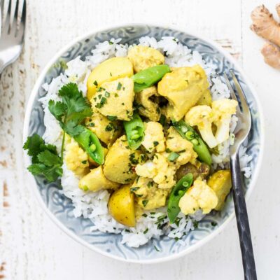 A serving of rice and thai curry in a blue bowl.