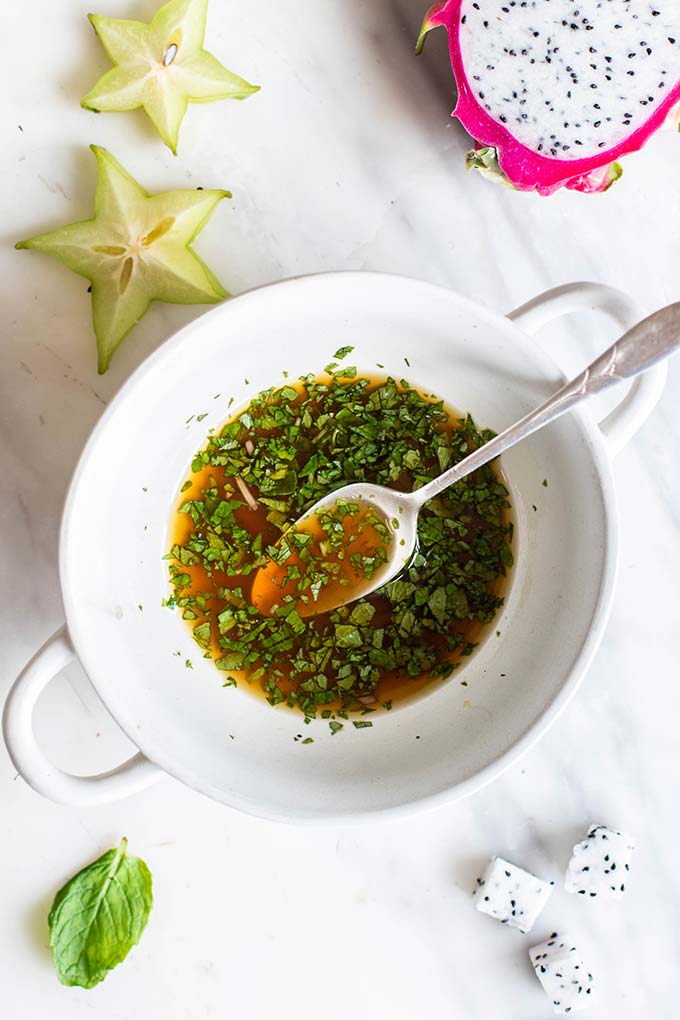 A white bowl filled with a honey mint vinaigrette.