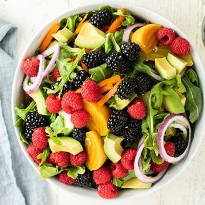 A salad bowl loaded with a spring arugula salad.