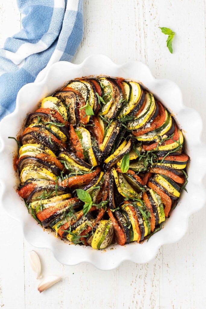 A baked ratatouille topped with parmesan and basil.