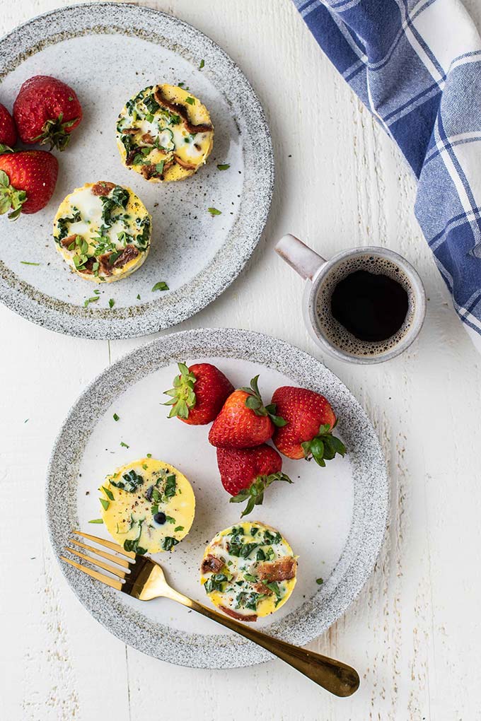 A top down look at two plates with Sous Vide Egg Bites and fruit.