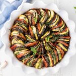 A baked ratatouille topped with parmesan and basil.