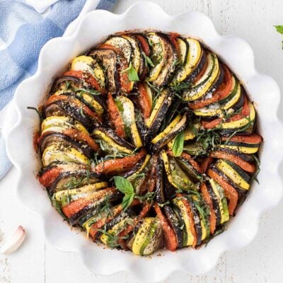 A baked ratatouille topped with parmesan and basil.