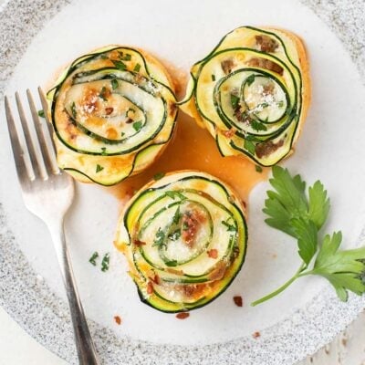 3 zucchini lasagna bites served on a white plate.