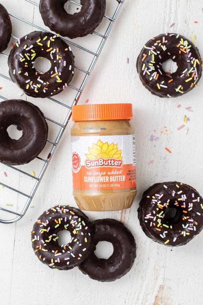 Decorated donuts surrounding a jar of SunButter.