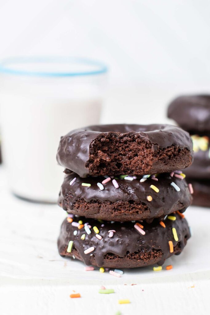 A stack of 3 donuts with sprinkles.