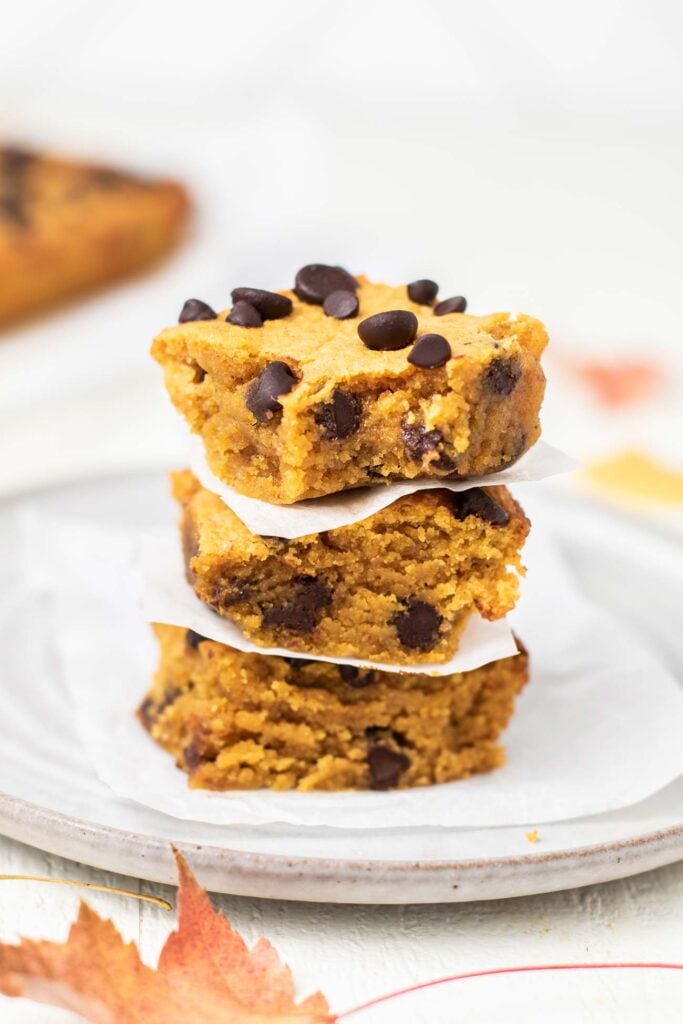 A stack of 3 pumpkin chocolate chip cookie bars.
