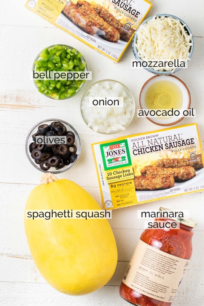 The ingredients needed to make sausage stuffed spaghetti squash shown prepared with labels.