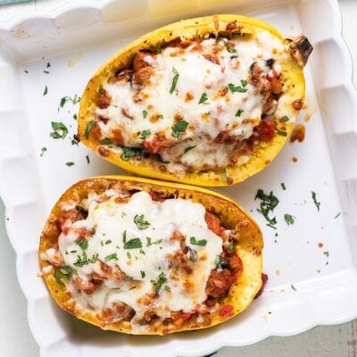 Two squash halves shown stuffed and baked with a layer of cheese on top.