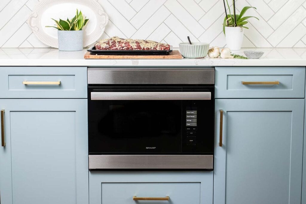 A tenderloin roast ready to be baked sitting on the counter by the Sharp SuperSteam Built in Wall Oven.