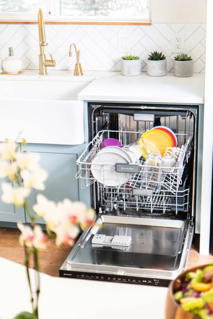 A dishwasher opened to show a half load of dishes.