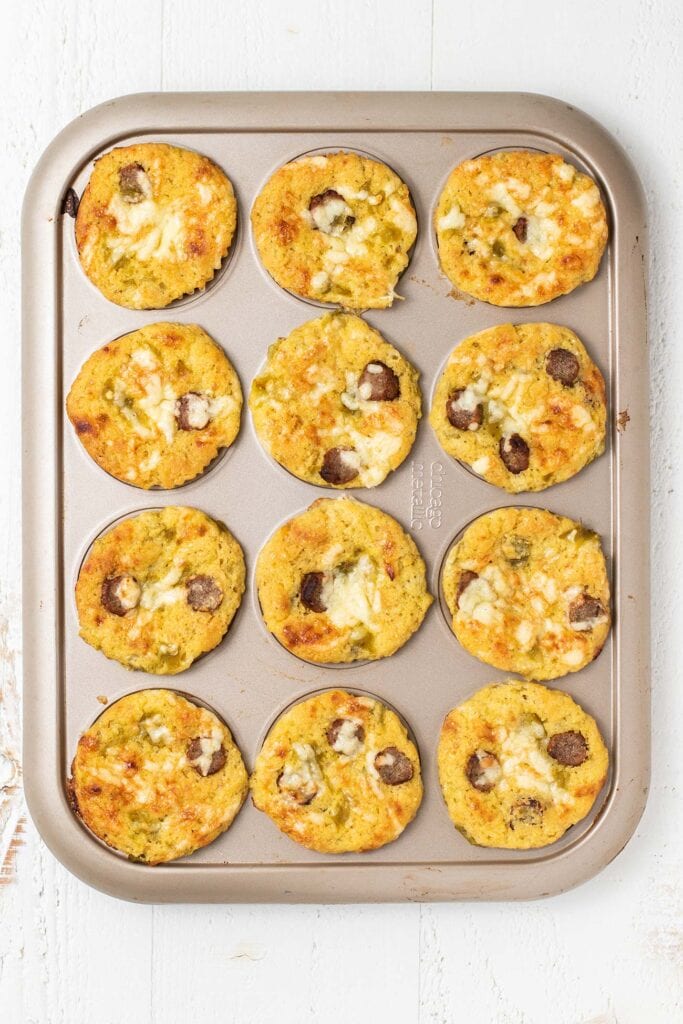 Baked gluten free cornbread muffins with sausage, cheese, and green chilis.