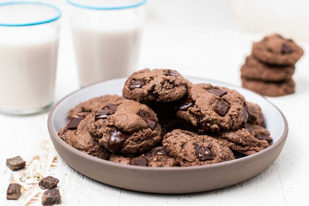 A white plate with dark chocolate cookies on it.