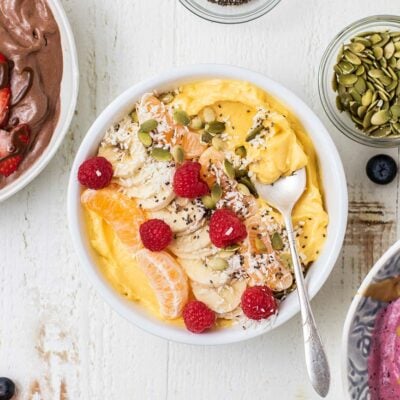 Three thick smoothie bowls shown with lots of toppings.